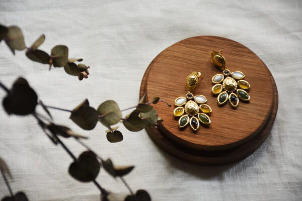 Ohrring in Gold vom Luzerner Label Pink Sand. Messing vergoldet, nickelfrei mit Stecker. Modernes, feminines Design aus einer Blume mit verschiedenen Halbedelsteinen. Jeder Stein ist einzeln eingefasst.