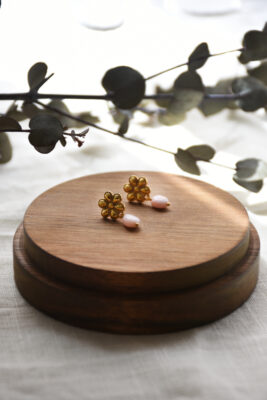 Ohrring in Gold vom Luzerner Label Pink Sand. Messing vergoldet, nickelfrei mit Stecker. Modernes, feminines Design aus einer Blume aus Gold mit Rosa Opal.