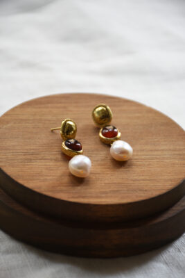 Ohrring aus Gold mit Karneol und Süsswasserperle vom Luzerner Label Pink Sand. Messing vergoldet, nickelfrei mit Stecker. Modernes, feminines Design bestehend aus drei asymetrischen Kreisen/Kugeln.