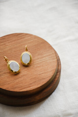 Ohrring in Gold mit Perlmutt vom Luzerner Label Pink Sand. Messing vergoldet, nickelfrei mit Klappbügel. Modernes, feminines Design aus einem goldenen Oval bestehend mit Perlmutt im Innern.